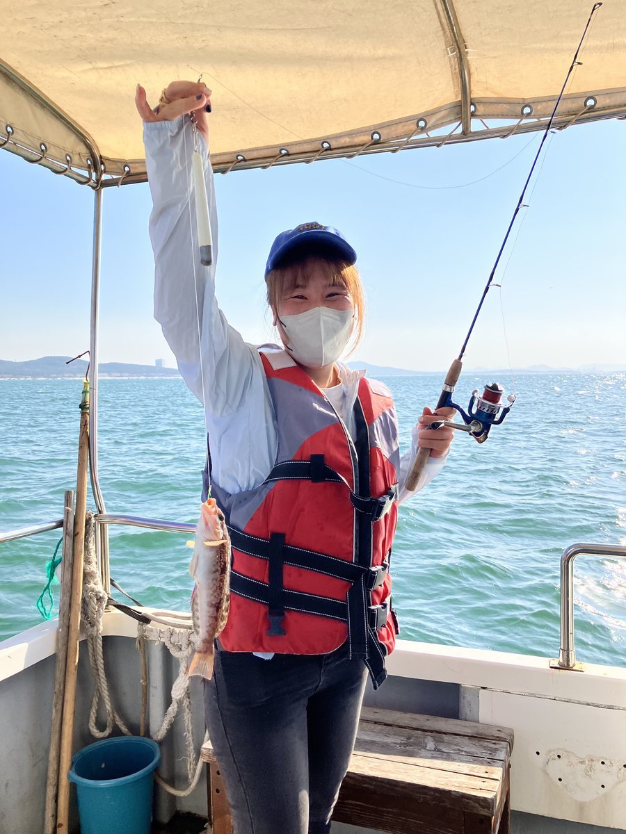A Chinalure team member on the boat under the awning, flat sea and clear sky off Weihai