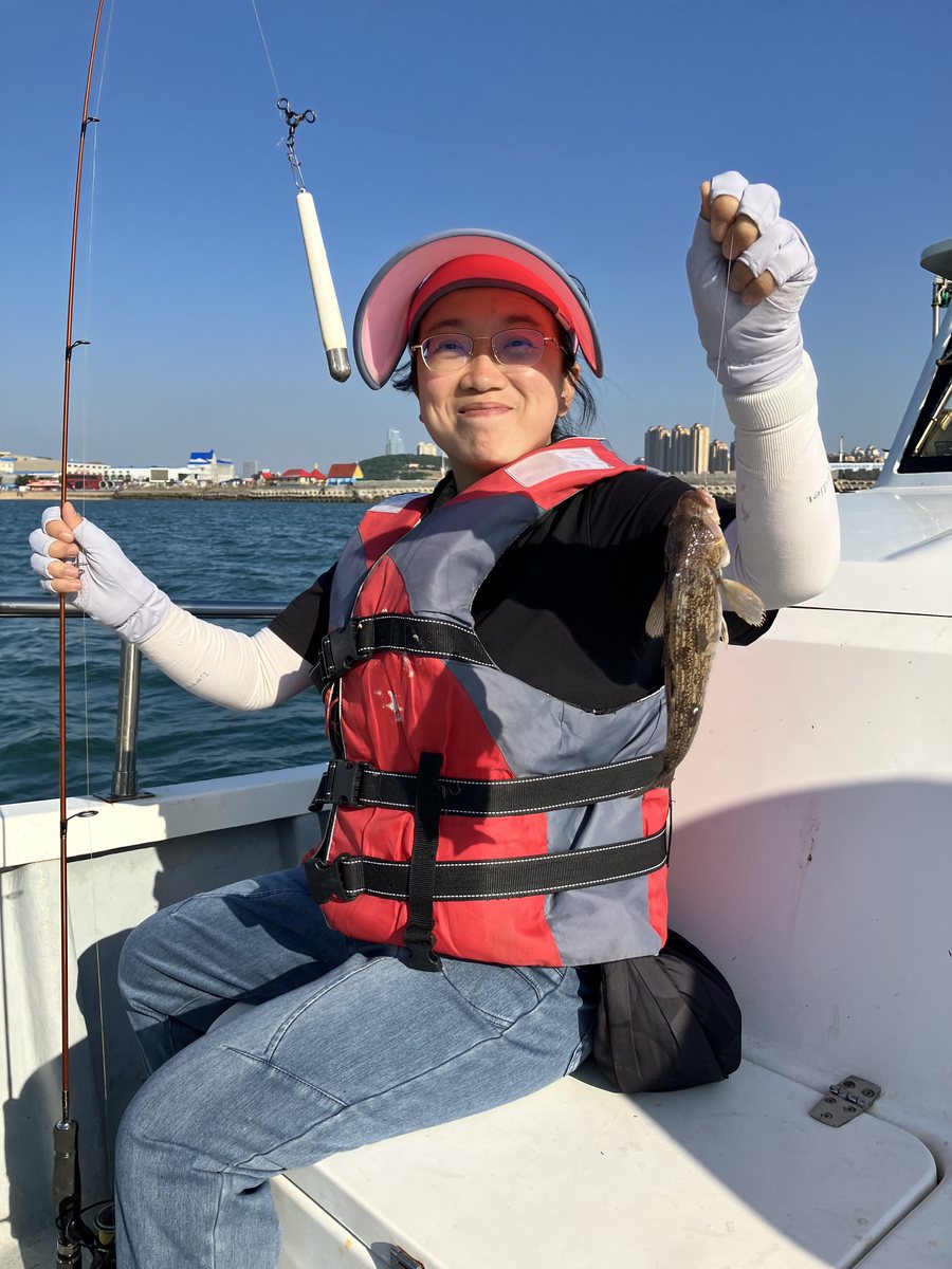 A second black fish held up beside the rail of the boat